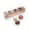 solid chocolate macrons in a long rectangle case with clear lid