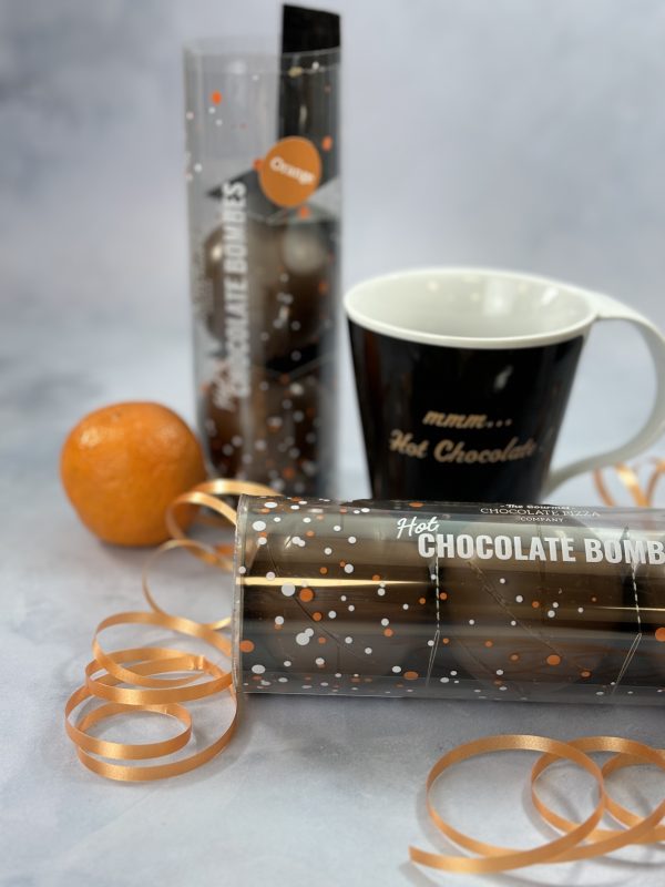 Orange flavour hot chocolate bombes, with a mug.