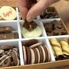 Chocolate grazing box being dipped into with a piece of chocolate