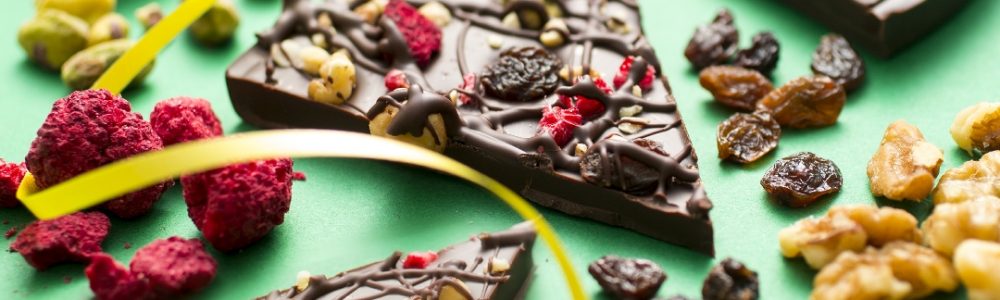 Decadent Dark chocolate pizza displayed as slices with ingredients and ribbon